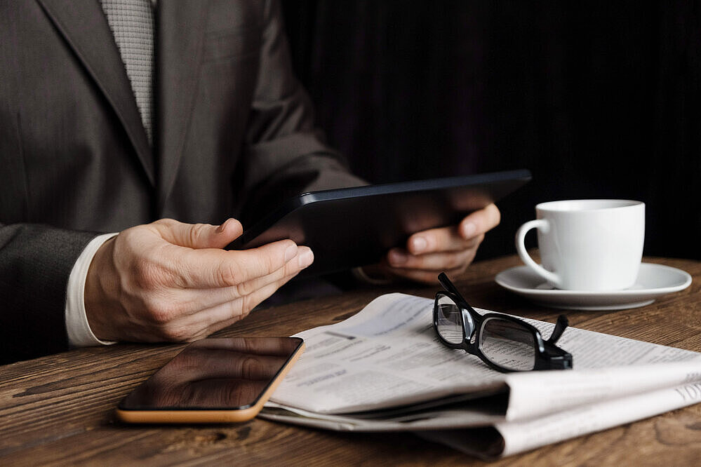 1729123855 The,Man,At,The,Table,Works,On,The,Tablet.,Nearby